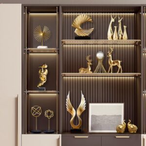 luxurious cabinet with golden decorative sculptures and dim lighting on shelves, including art pieces, animal figurines, and framed artwork.